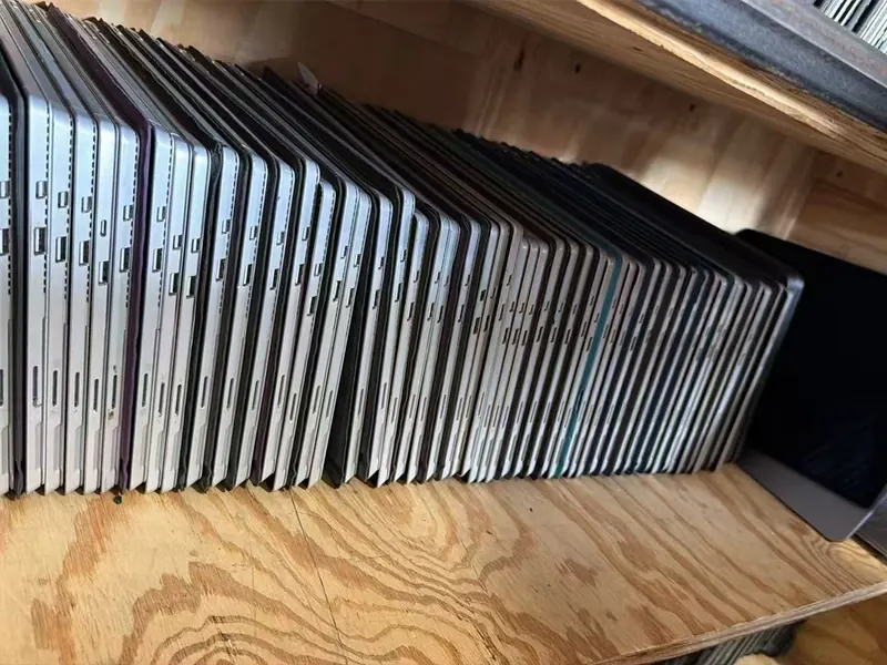 Rows of used laptops lined up on warehouse shelves